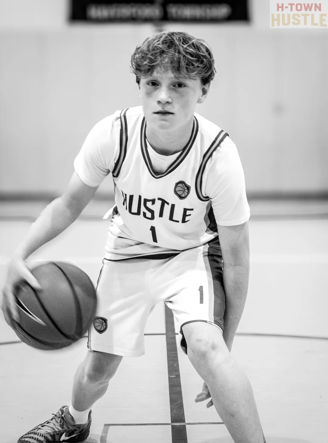 Black and white photograph of a H-Town Hustle player dribbling a basketball