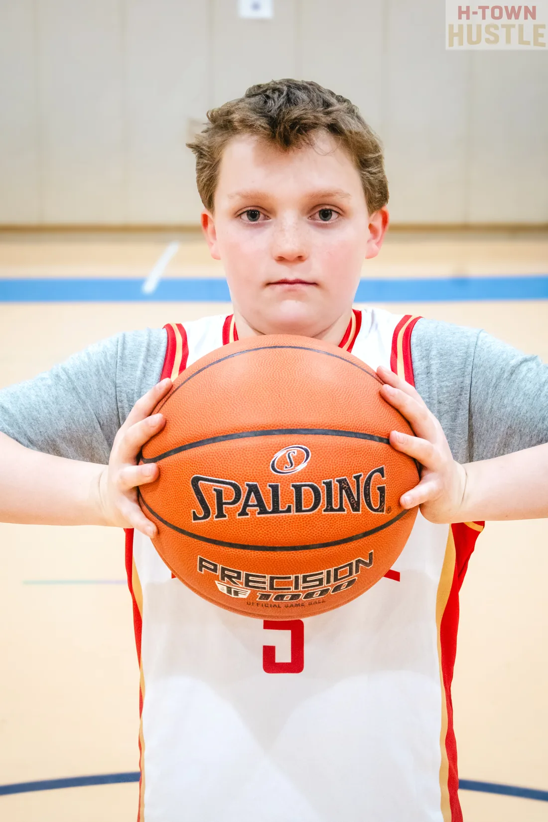H-Town Hustle player holding a basketball in front of his jersey