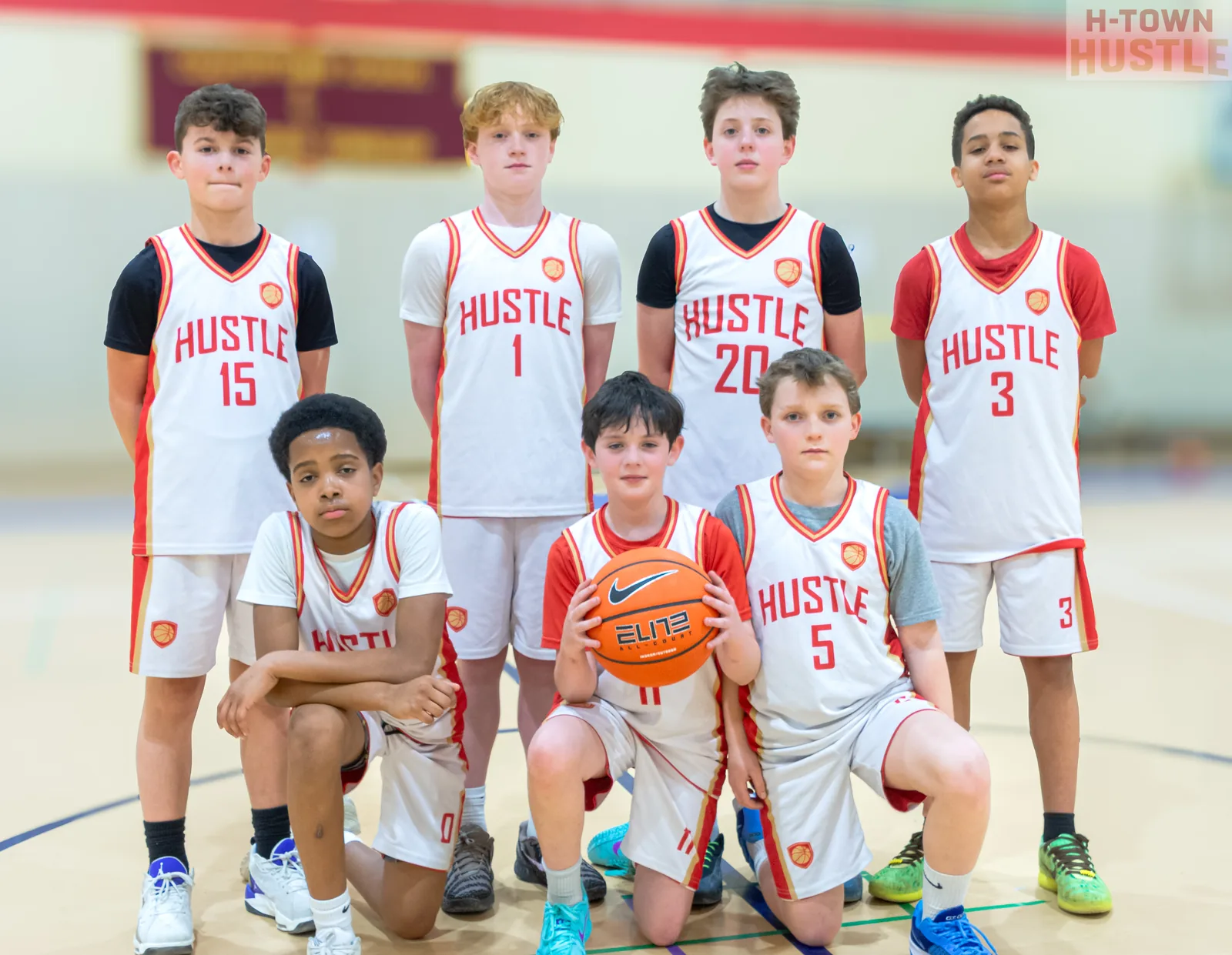 H-Town Hustle basketball team posing together in white uniforms